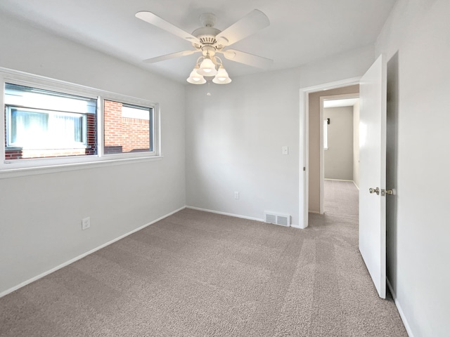 carpeted spare room with ceiling fan