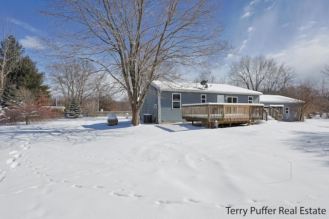 snow covered property with a wooden deck