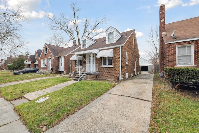 view of front of home with a front yard, an outdoor structure, and a garage