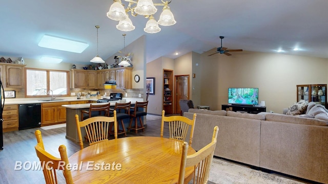 dining area with light wood-style floors, high vaulted ceiling, and ceiling fan with notable chandelier