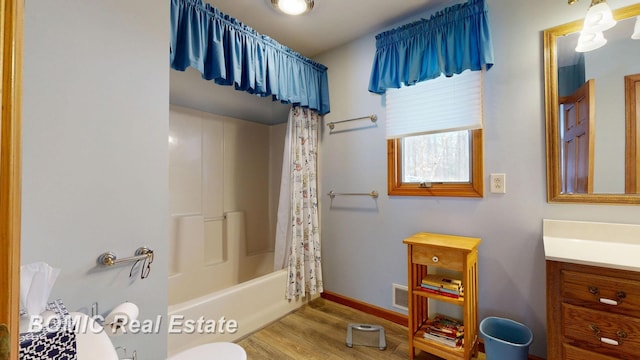 bathroom with visible vents, toilet, shower / tub combo, vanity, and wood finished floors