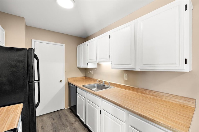 kitchen with a sink, black appliances, light countertops, and white cabinets