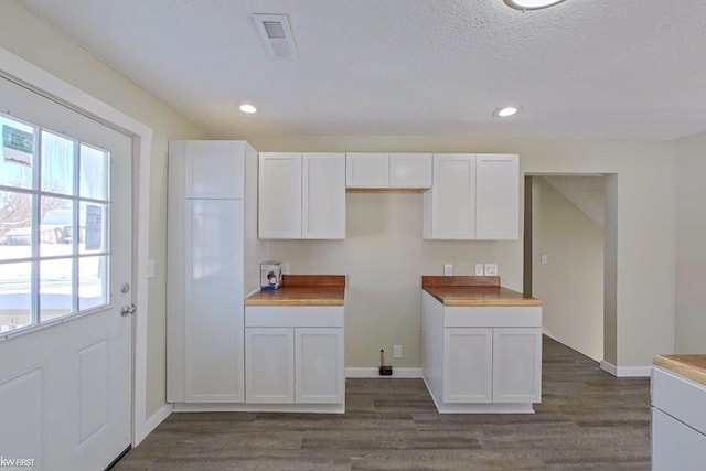 kitchen featuring white cabinets, wooden counters, a textured ceiling, and dark hardwood / wood-style floors