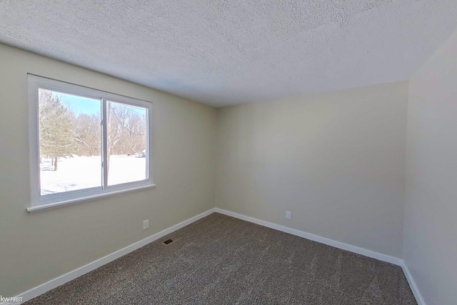 carpeted spare room with a textured ceiling