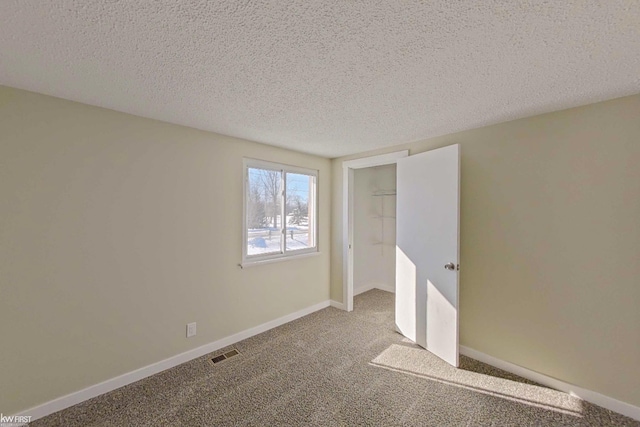 unfurnished bedroom featuring carpet flooring, a textured ceiling, and a closet