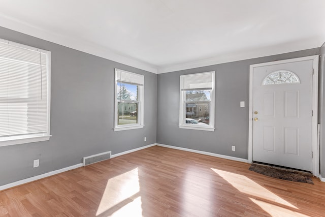 foyer featuring visible vents, baseboards, and wood finished floors