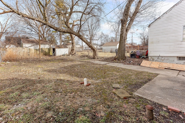 view of yard featuring fence, a storage unit, and an outdoor structure