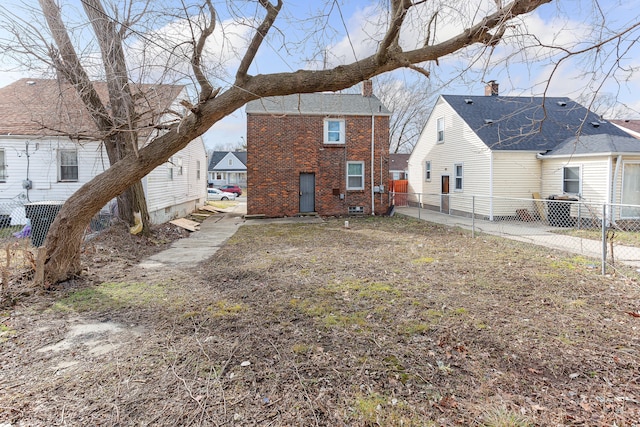 rear view of property with fence and brick siding