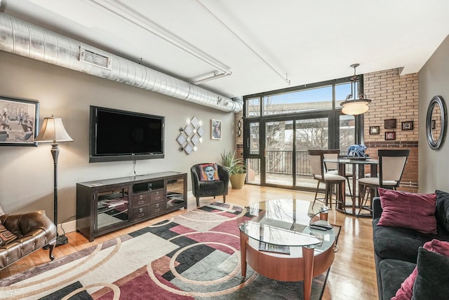 living room with a wall of windows and light hardwood / wood-style flooring