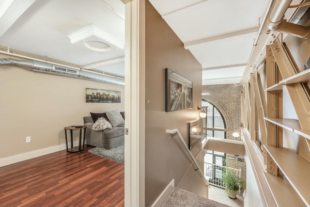 hall featuring brick wall and dark hardwood / wood-style floors