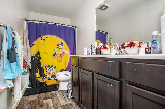 bathroom featuring vanity, toilet, and hardwood / wood-style floors