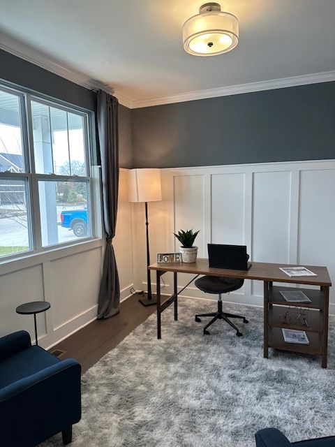 office area with a wainscoted wall, ornamental molding, a decorative wall, and wood finished floors