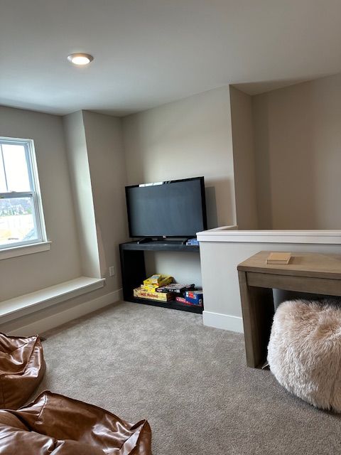 carpeted living area with baseboards