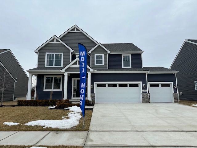 craftsman-style house with driveway, stone siding, an attached garage, and a garage