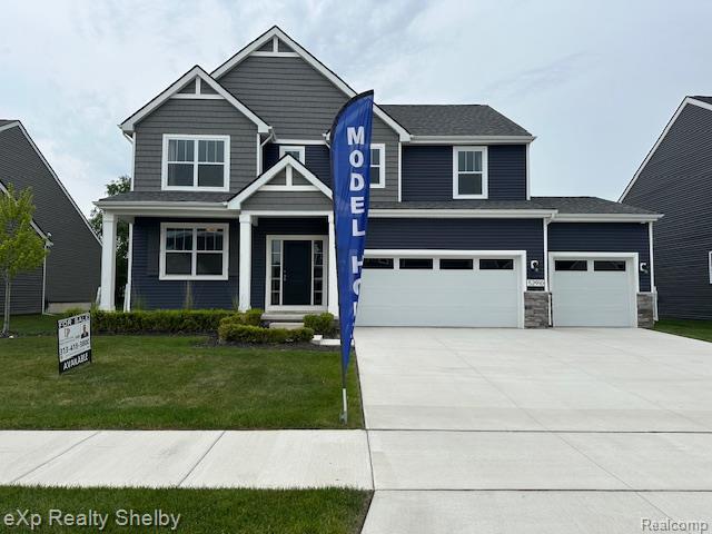 52910 Wellington Valley Dr, Macomb, MI 48042 - view of front facade featuring concrete driveway, a front lawn, and an attached garage