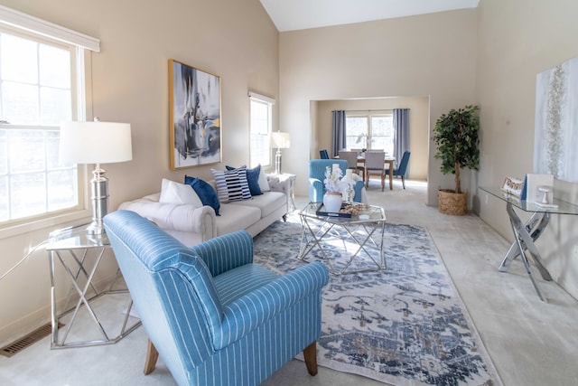 carpeted living room with a towering ceiling and visible vents