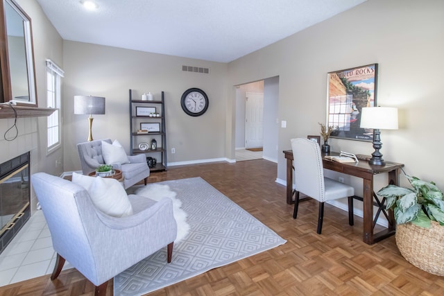 office with baseboards, a fireplace, visible vents, and a wealth of natural light