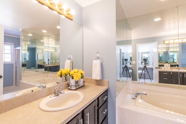 bathroom with ornamental molding, recessed lighting, vanity, and a bath