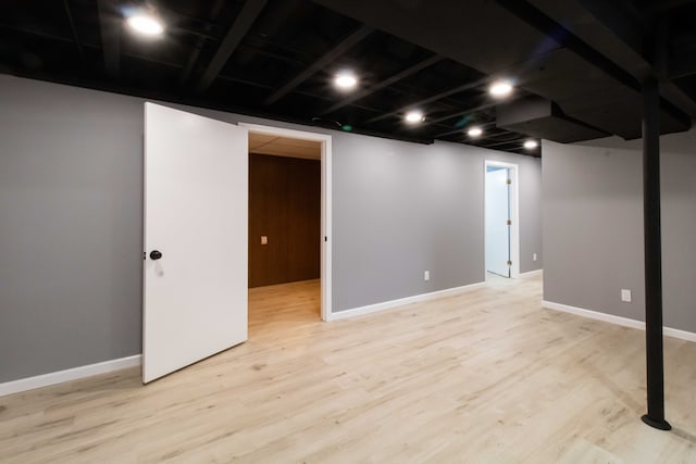 finished basement featuring baseboards and light wood-style floors