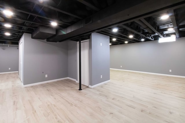 finished basement featuring baseboards and light wood finished floors