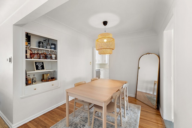 dining area featuring light hardwood / wood-style flooring and built in shelves