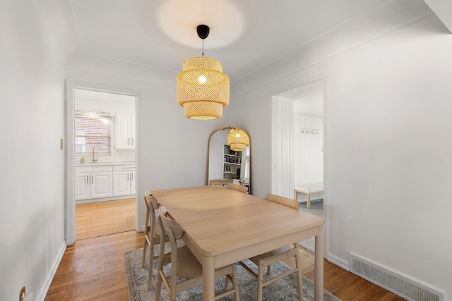 dining space featuring light hardwood / wood-style flooring and sink