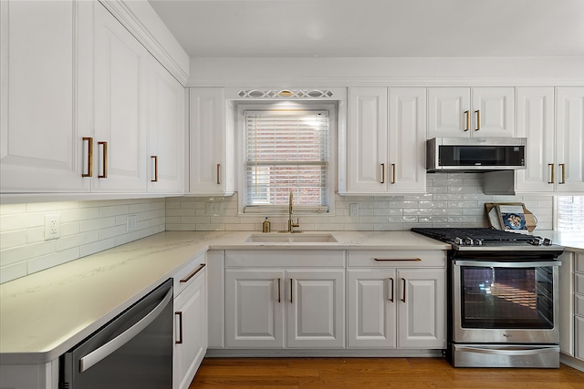 kitchen with appliances with stainless steel finishes, sink, and white cabinets