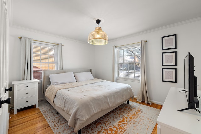 bedroom with crown molding and light hardwood / wood-style floors