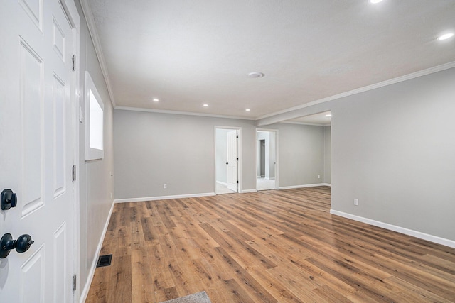 unfurnished room with ornamental molding, visible vents, baseboards, and wood finished floors