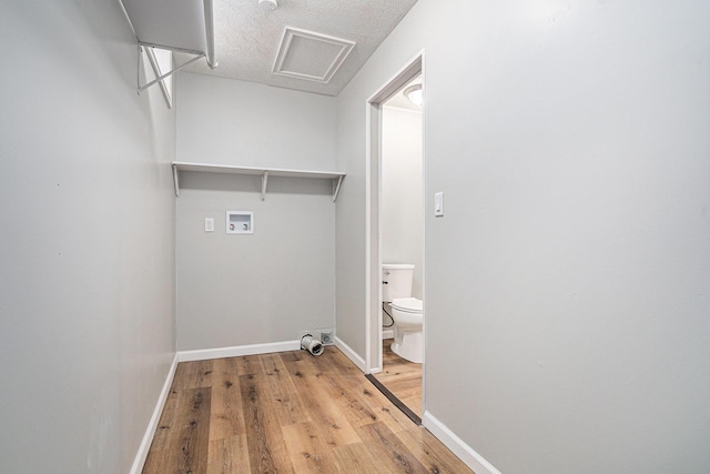 washroom featuring laundry area, attic access, light wood finished floors, baseboards, and hookup for a washing machine