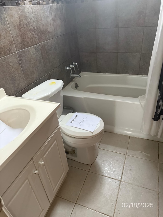 full bathroom featuring shower / bath combo with shower curtain, tile walls, vanity, toilet, and tile patterned floors