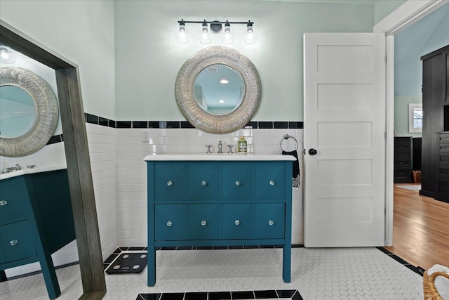 bathroom with tile walls, vanity, and tile patterned flooring