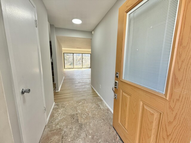 hall with stone finish flooring and baseboards