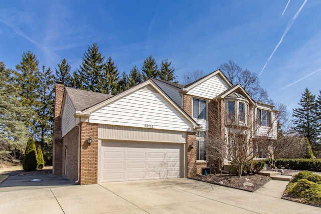 traditional home with driveway, brick siding, an attached garage, and a chimney