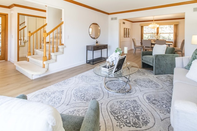 living room with baseboards, stairs, ornamental molding, an inviting chandelier, and wood finished floors