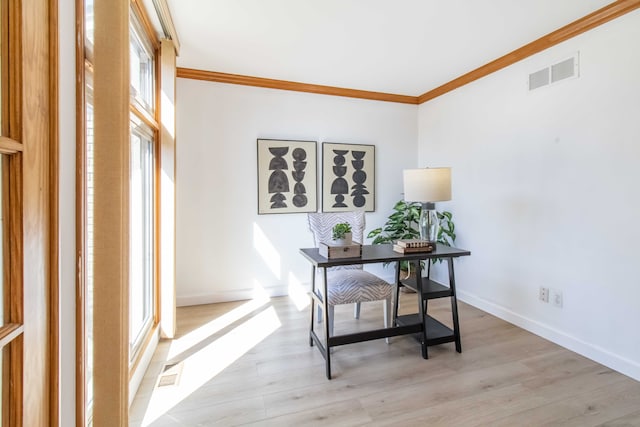 office area with light wood-type flooring, visible vents, and crown molding