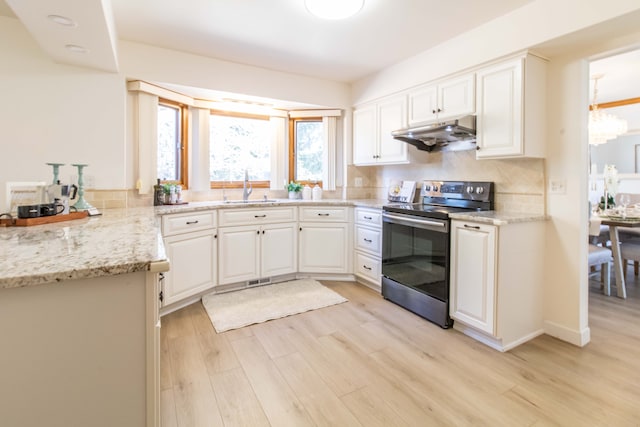 kitchen featuring light wood-style flooring, under cabinet range hood, a sink, backsplash, and stainless steel electric stove