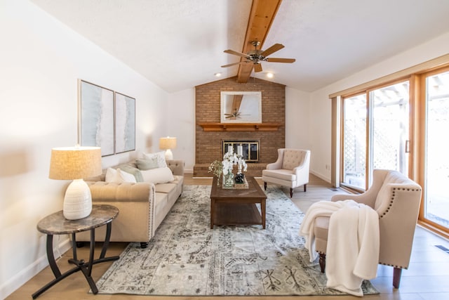 living room featuring plenty of natural light, a brick fireplace, vaulted ceiling with beams, and wood finished floors