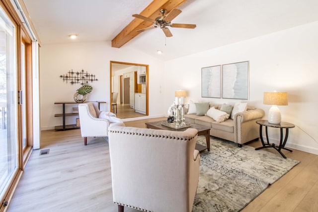 living area with visible vents, light wood-style flooring, a ceiling fan, baseboards, and vaulted ceiling with beams