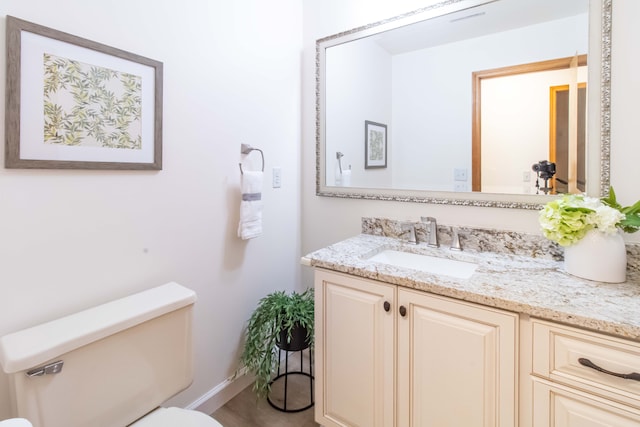 half bathroom with toilet and vanity