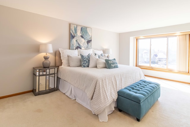 bedroom with light carpet and baseboards