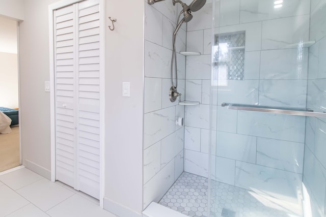 bathroom featuring tile patterned floors, a stall shower, and baseboards