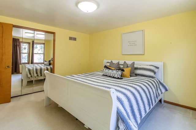 bedroom with light carpet, visible vents, baseboards, and a closet