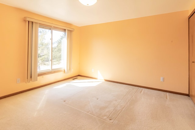 unfurnished room featuring carpet flooring and baseboards