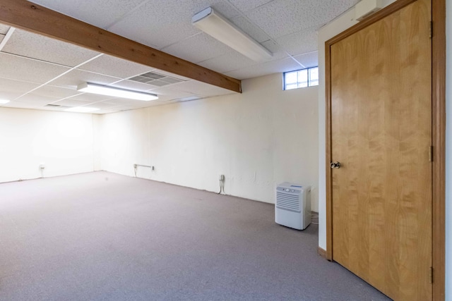 basement featuring visible vents, a paneled ceiling, and carpet flooring