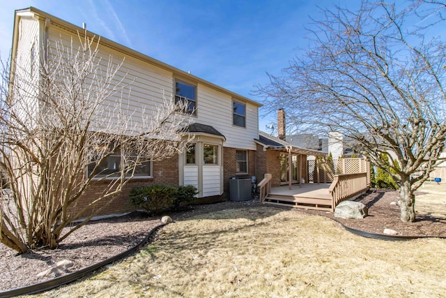 back of house with a wooden deck, brick siding, and central AC