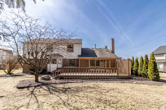 back of property with brick siding, a chimney, and a wooden deck