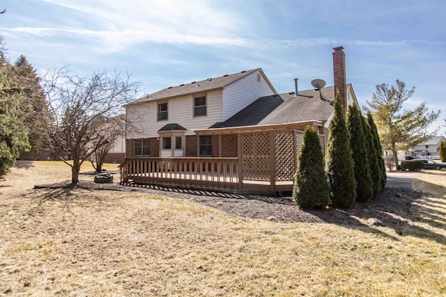 rear view of house featuring brick siding, a deck, and a chimney