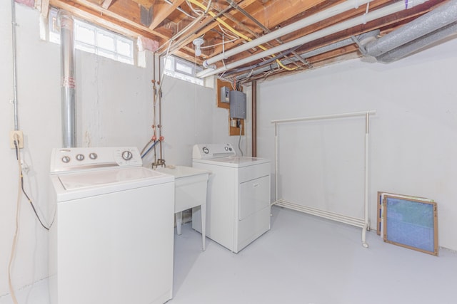 laundry area with electric panel, sink, and washing machine and clothes dryer