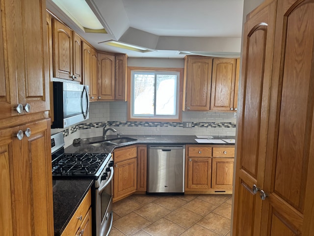 kitchen featuring appliances with stainless steel finishes, light tile patterned flooring, sink, and backsplash